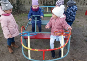 Dzieci bawią się w ogrodzie z wykorzystaniem sprzętu ogrodowego
